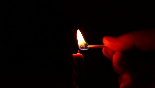 lighting candle with match