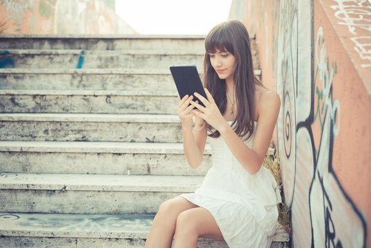 beautiful young woman with white dress using tablet