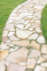 Natural brown stone pathway and green grass