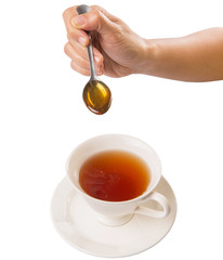 Female hand mixing honey with tea over white background
