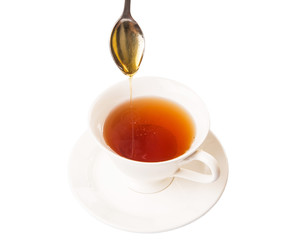 Mixing honey with tea with a tea spoon.