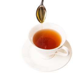 Mixing honey with tea with a tea spoon.