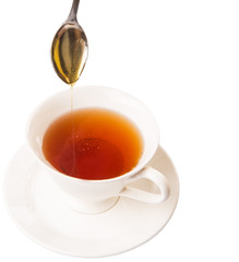 Mixing honey with tea with a tea spoon.