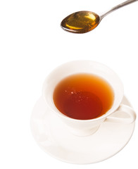 Mixing honey with tea with a tea spoon.