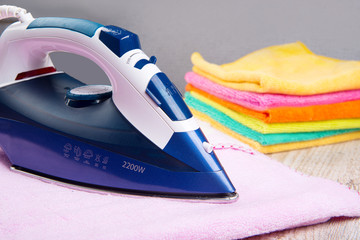 Steam iron and  with clothes, on bright backgroundм