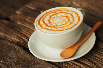 caramel coffee in white cup on wood table