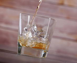 Pouring brandy into glass with ice