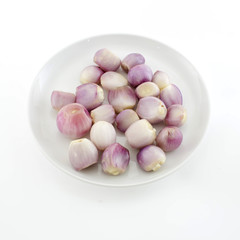 close up of a bowl of peeled shallots isolate white background