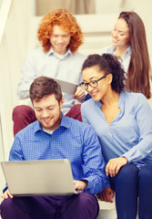 team with laptop and tablet pc on staircase