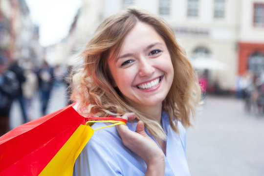 Frau mit blonden Locken hat Spass beim Einkaufen