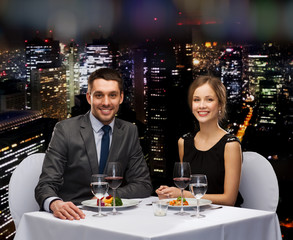smiling couple eating main course at restaurant