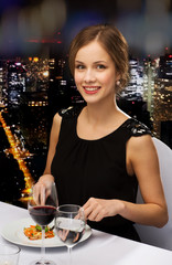 smiling young woman eating main course