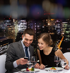 smiling couple eating main course at restaurant