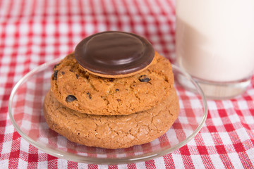 three different cookies and a glass of milk
