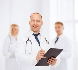 smiling male doctor with clipboard and stethoscope
