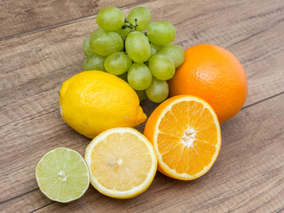 Fototapeta na wymiar Grapes And Citrus Fruits On Wood Table
