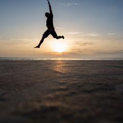 silhouetted man jumping in sunset