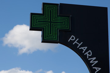 signe de pharmacie avec la croix verte en éclairage urbain