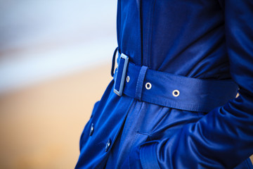 Female fashion. Closeup blue coat wit belt