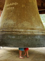 Tourist couple standing inside Mingun bell, Mandalay region, Mya