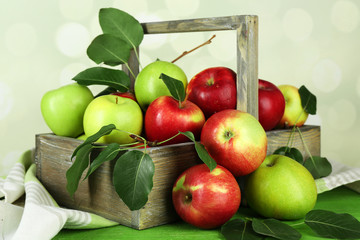 Ripe apples in crate on bright background
