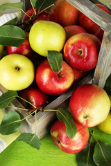 Ripe apples in crate on table close up