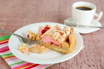 Piece of tasty pie with apples and berry mousse and cup of