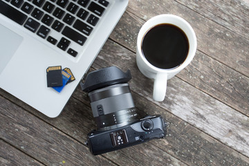 Laptop with digital camera and a coffee cup.