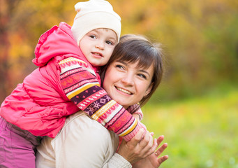 happy mother with kid girl outdoor in autumn park