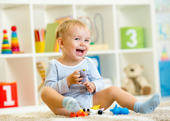 kid playing with toy animals indoors
