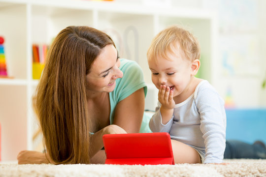 Mother And Kid Play At Tablet Computer