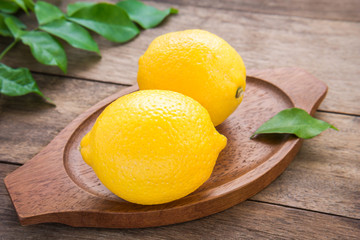Fresh lemons on wooden plate