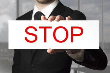 businessman holding sign stop