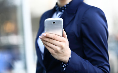 Young beautiful woman writes an SMS to your mobile phone