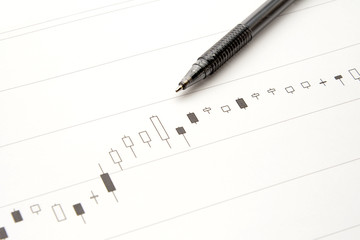 資産運用イメージ―株価のチャートとボールペン