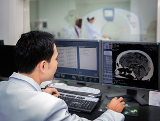 Medical team operating computers in CT scan lab