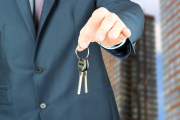 Cropped image of estate agent giving house keys outside