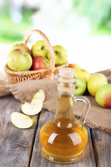 Apple cider vinegar in glass bottle and ripe fresh apples,