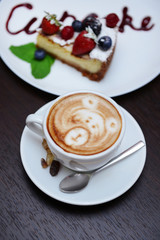 Cup of coffee with cute drawing in cafe