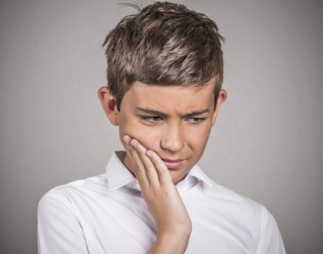 Headshot young man with sensitive tooth ache grey background 