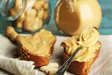 Tasty sandwiches with fresh peanut butter on wooden background