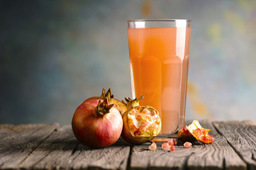 Glass of pomegranate juice on wooden