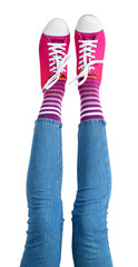 Female legs in colorful socks and sneakers isolated on white