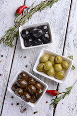 Different marinated olives on table close-up