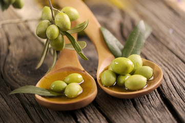 Close-up of olives on two wooden ladle spoon