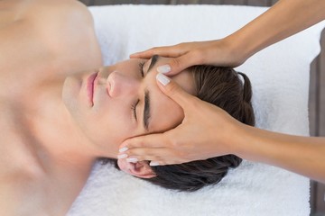 Man receiving head massage at spa center