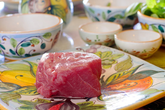 raw tuna fillet with vegetables in the background