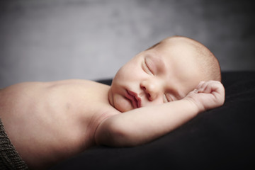 Newborn baby boy sleeping in studio