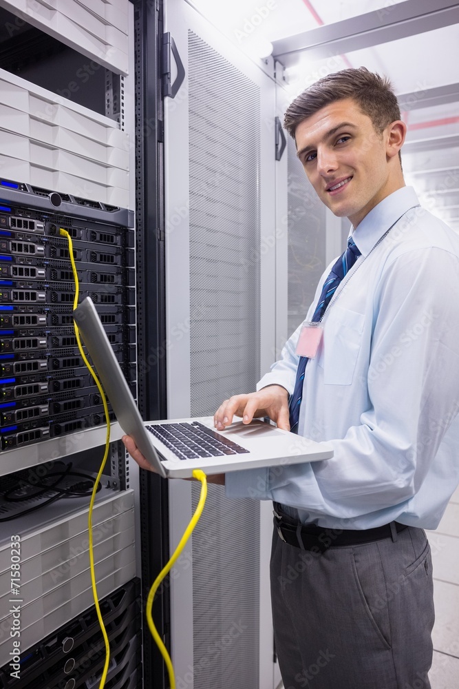 Aufkleber Portrait of a technician using laptop while analysing server