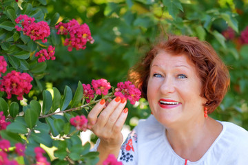 Mature  red haired woman  dressed in an embroidered blouse with